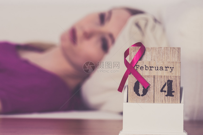 躺在床上的妇女看着日历今天是4个世界乳癌日与粉红色认识丝带约会保健和医学概念睡觉的妇女日历上世界乳腺癌日图片