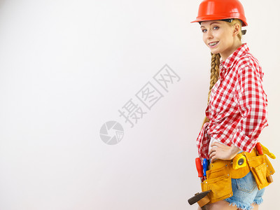 穿着头盔和检查衬衫的快乐妇女对建筑工作持肯定态度图片