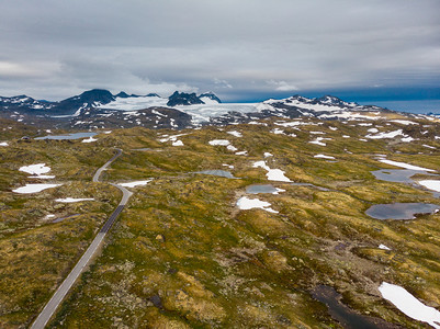 穿越山地的公路远处雪峰和冰川旅游景点5Sognefjellet挪威空中视图山地景观挪威路线Songnefjellet索涅菲耶尔斯维根高清图片素材
