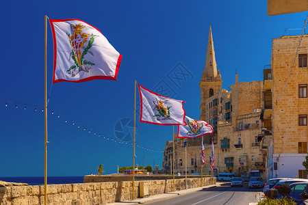 在马耳他瓦莱塔老城马耳他瓦莱塔配有马耳他主权军事教团全体大主旗帜的盛装街道饰马耳他瓦莱塔老城的街道背景图片