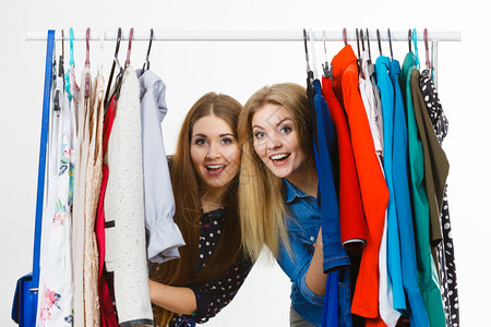 快乐的年轻女子在购物时挑衣服穿尚装快乐的女子买衣服生活方式高清图片素材