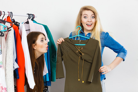 支吊架2名女青年在购物时为朋友挑拣完美的临时短裙背景