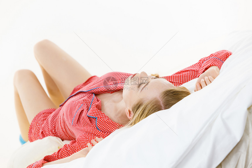 睡梦中溺水的女孩穿着红色圆点睡衣的年轻女人躺在床上做梦图片