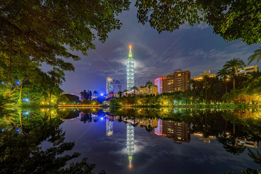 台北公园花和摩天大楼的反射图片