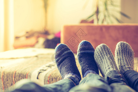 冬季脚和羊绒袜子夫妻在沙发上放松图片