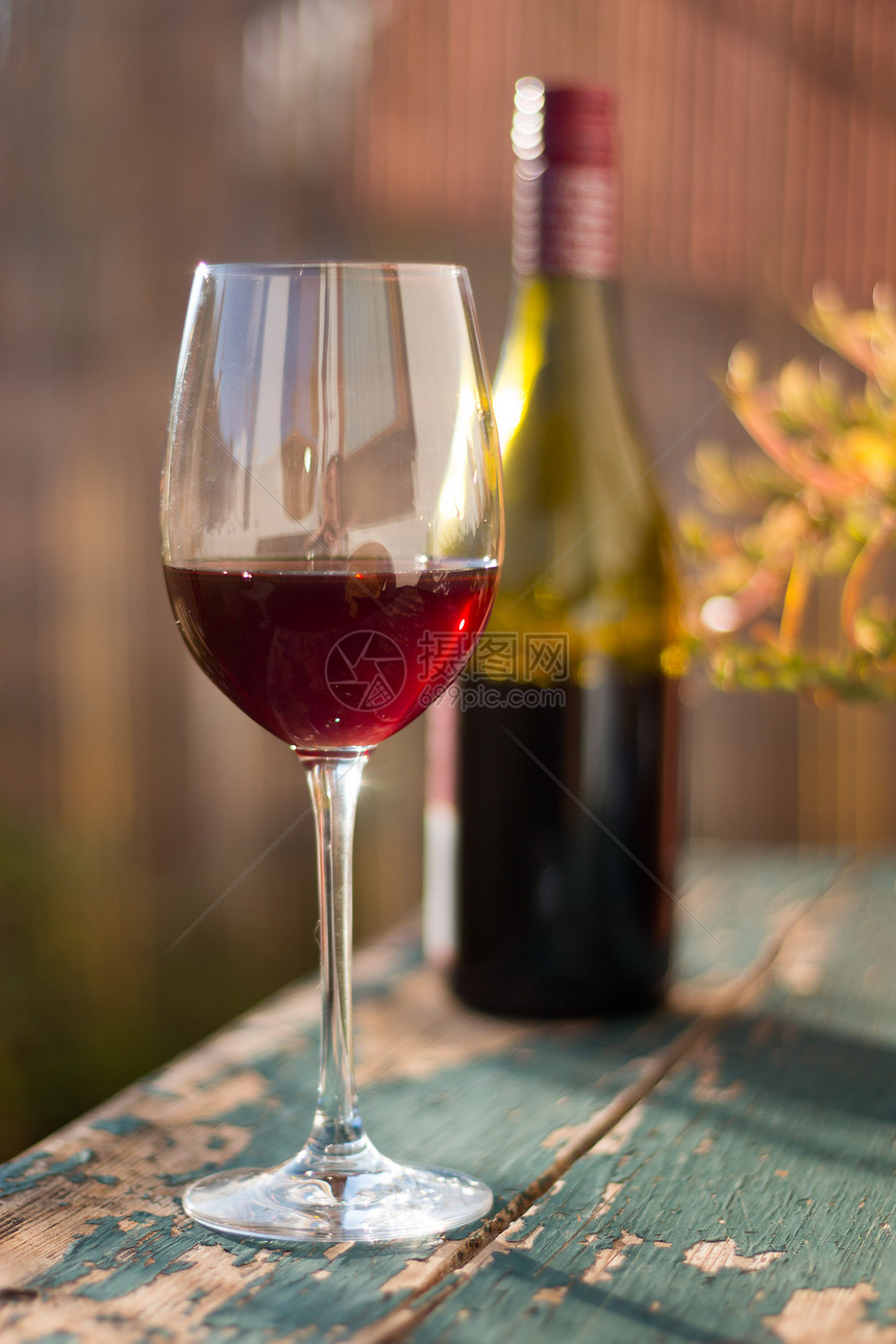 红酒杯放在老旧的木制桌子上在晚的阳光下在自己的花园里享受它图片
