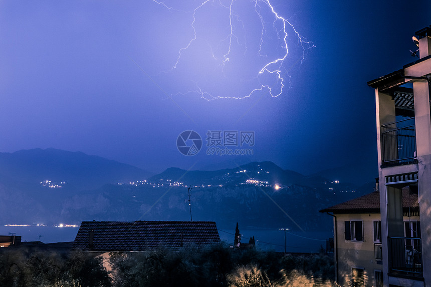 在云天山和湖上闪亮建筑在意大利的地平面图片