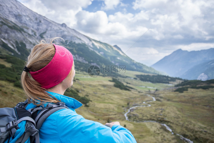 穿运动服和背包的妇女享受山区风景图片