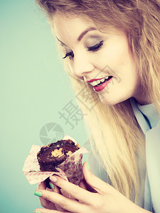 迷人的金发美女手握着味的巧克力蛋糕渴望美味的甜点迷人女子手握着蛋糕图片