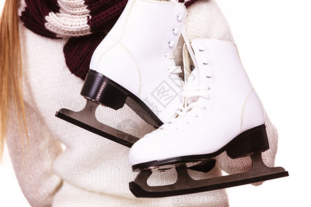 白色溜冰鞋带着一对冰鞋的妇女准备去滑冰冬季体育活动背景