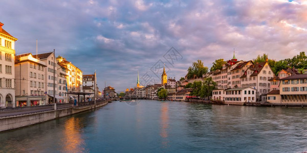著名的Fraumunster和圣彼得教堂以及瑞士最大的城市苏黎世最大的城市苏黎世老日落时的Limmat河的全景日出高清图片素材
