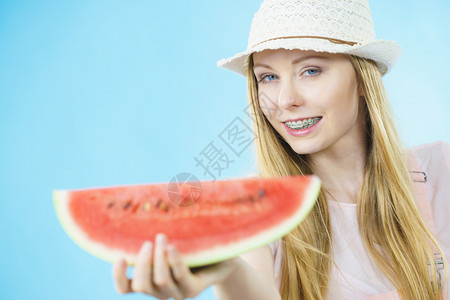 拿西瓜的女孩快乐的十几岁女孩准备过暑假戴着太阳帽拿甜果子红色多汁西瓜蓝女人拿着西瓜水果背景