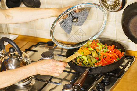 许多人在煎锅上切开健康的蔬菜素食烹饪图片