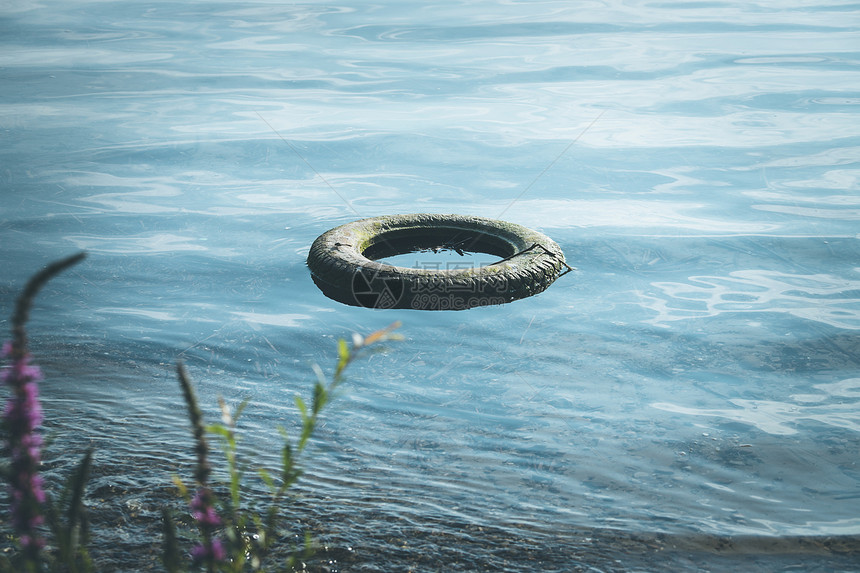 旧轮胎位于水海岸线环境污染中图片