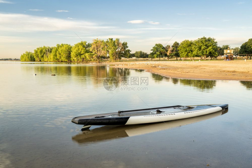 在科罗拉多州博伊德湖立公园的海滩上用桨和安全套领带用桨和安全套领带起身桨板图片