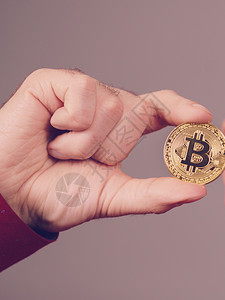 手握金比特币硬符号的人是新虚拟货币的数字符号图片