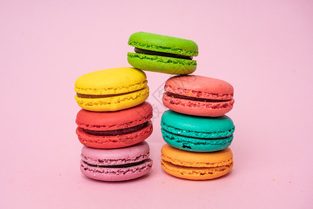 粉红背景的多彩马卡龙甜美和彩色的法国马卡龙背景图片