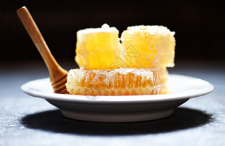 蜂巢蜂窝新鲜蜂蜜健康食品黄色甜蜂窝切片白板和黑底有木花背景
