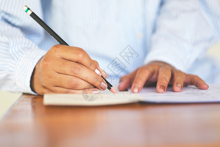 高中大学生在考试参加期末学生持有笔写在纸质回答单课堂教育学院上在考试室学习写作选择背景图片