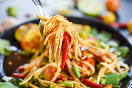在叉口上的木瓜沙拉在桌边选择焦点上关闭绿木瓜沙拉辣色泰语食品图片