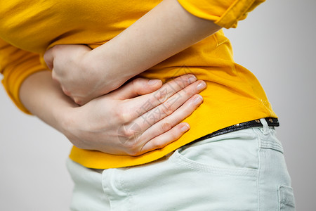 坚强的女人保健概念Bellyache消化不良或月经年轻女患灰色腹痛的胃女腹背景