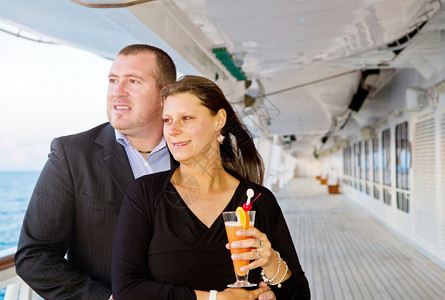 在船甲板上喝鸡尾酒的情侣图片