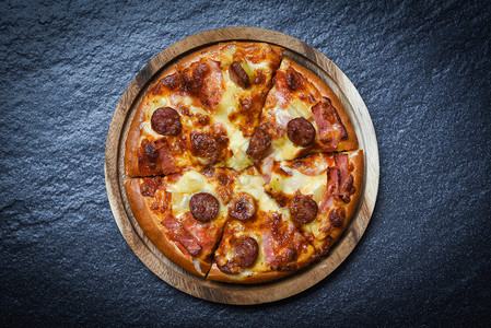 木盘上披萨切片美味可口的快餐意大利传统披萨奶酪和莫扎里拉熏猪肉香肠菠萝火腿酱面团高清图片素材