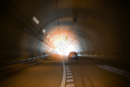 光方向公路隧道高速隧道高速交通车的速隧道尽头带模糊过滤器的有亮光街道交通车速背景