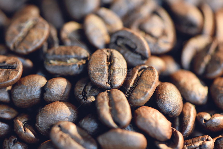 咖啡豆的紧闭在质地背景和阳光的早晨图片