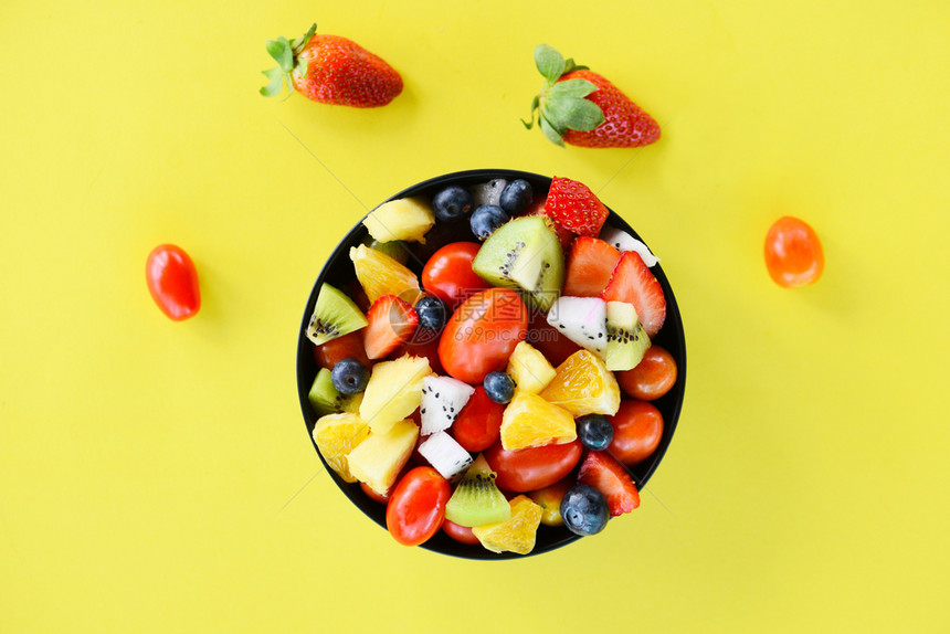 水果沙拉碗新鲜夏季水果和蔬菜健康有机食品草莓橙木蓝龙果热带葡萄黄底菠萝番茄柠檬图片