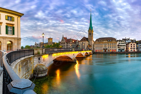 瑞士最大的城市苏黎世老日落时著名的Fraumunster教堂和Munsterbrucke桥在瑞士最大的城市苏黎世Limmat河上尖塔高清图片素材