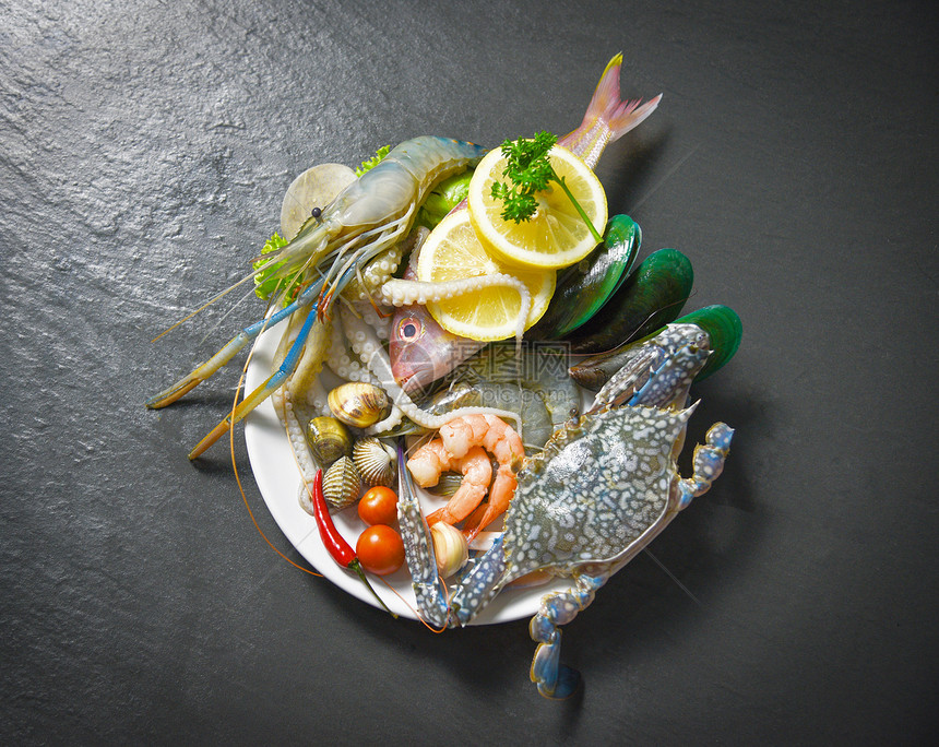 贝壳鱼海鲜板和虾蟹壳鱿鱼和海和洋美食晚餐新鲜生海底有草药和香料柠檬图片