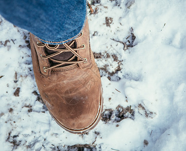 穿蓝色牛仔裤的男人在冬季双腿和鞋子上徒步旅行图片