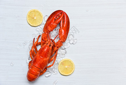 烤的虾红色冰海鲜虾的龙和白木桌上的柠檬背景