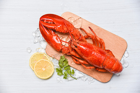 烤的虾红色龙虾海鲜木制切板上加冰和柠檬椰菜关闭蒸龙虾食物背景
