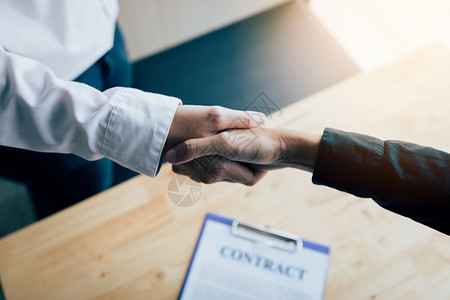 两个人在办公室里握手签个合同背景图片