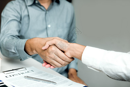 有自信的合伙关系人们在办公室里握手签订合同图片