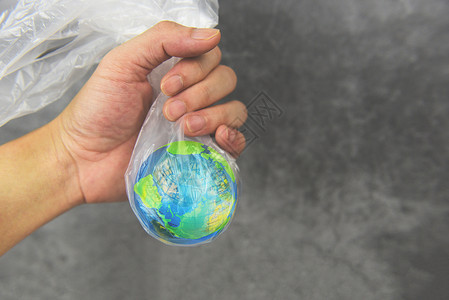塑料世界或环境日概念手将地球置于塑料袋禁令中止塑料袋称污染零废物回收图片
