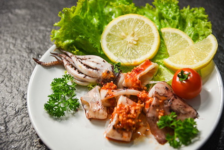 海鲜餐厅盘子上的鱿鱼切片带有辣椒酱药草和香料的斯奎德沙拉图片