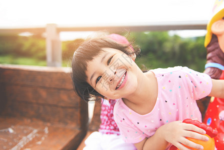 孩子们笑着玩开心的小女孩在花园公玩乐坐在操场国际儿童图片