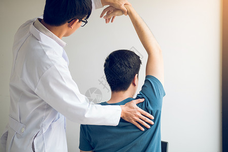 肩袖损伤在医务室伸展一名年轻男子手臂背景