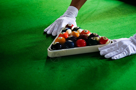 白色的球Man手和Cue臂在玩Snooker游戏或准备在绿色球桌上绿色盘上有多彩的Snooker球背景