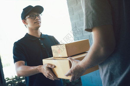 亚洲货运承人持有一个纸箱里面装着货包接收方正在签署货包包裹高清图片素材