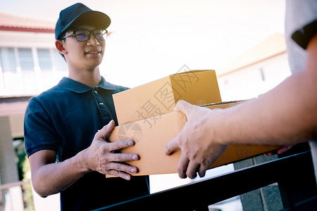 货物工作人员把装有包裹的纸板箱交给收货人手图片