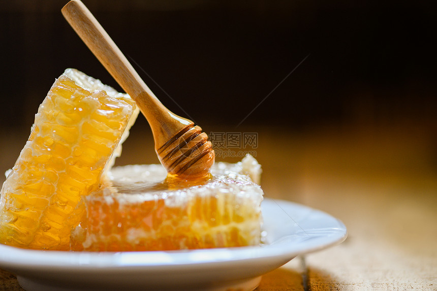 新鲜蜂蜜健康食品黄色甜蜂窝切片白板和黑底有木花图片