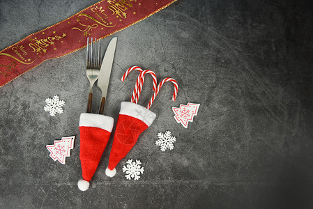 圣诞餐桌位装饰圣塔克拉斯帽的叉刀和糖果甘蔗圣诞新年晚宴的背景图片