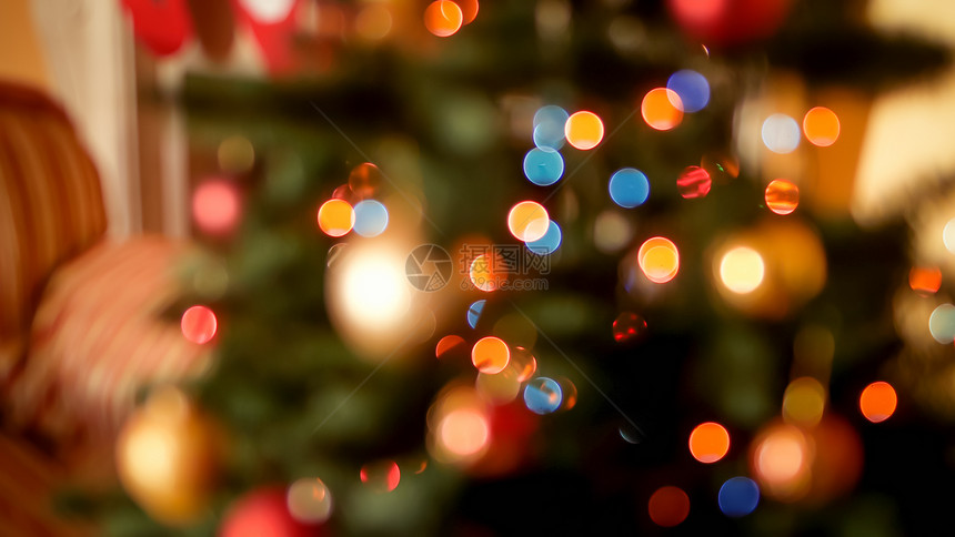 在客厅的圣诞树上闪耀着明亮的圣诞灯光和彩色长袍的画面摘要模糊冬季假日和庆祝活动的完美背景圣诞灯光的亮度和客厅圣诞树上的彩色长袍和图片