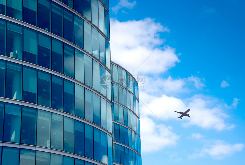 一架喷气飞机在高楼上空飞过图片