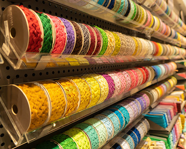 纺织业购物商场零售店的书架上堆满了多彩的缝纫线在书架上的缝纫线背景图片