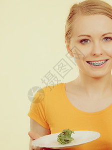 快乐的年轻女子即将吃着盘和微笑的生菜满图像颜色的微笑着女子拿盘和生菜背景图片